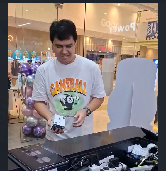 Customer rolling the Flip and Fold dice at the in-store standee